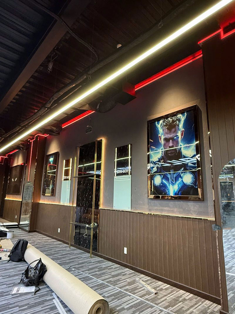 Không gian tường trang trí phong cách điện ảnh với tranh LED Thor nổi bật, kết hợp đường viền ánh sáng đỏ và ốp gỗ hiện đại – tạo nên chất riêng đầy cá tính cho khu vực bida giải trí.